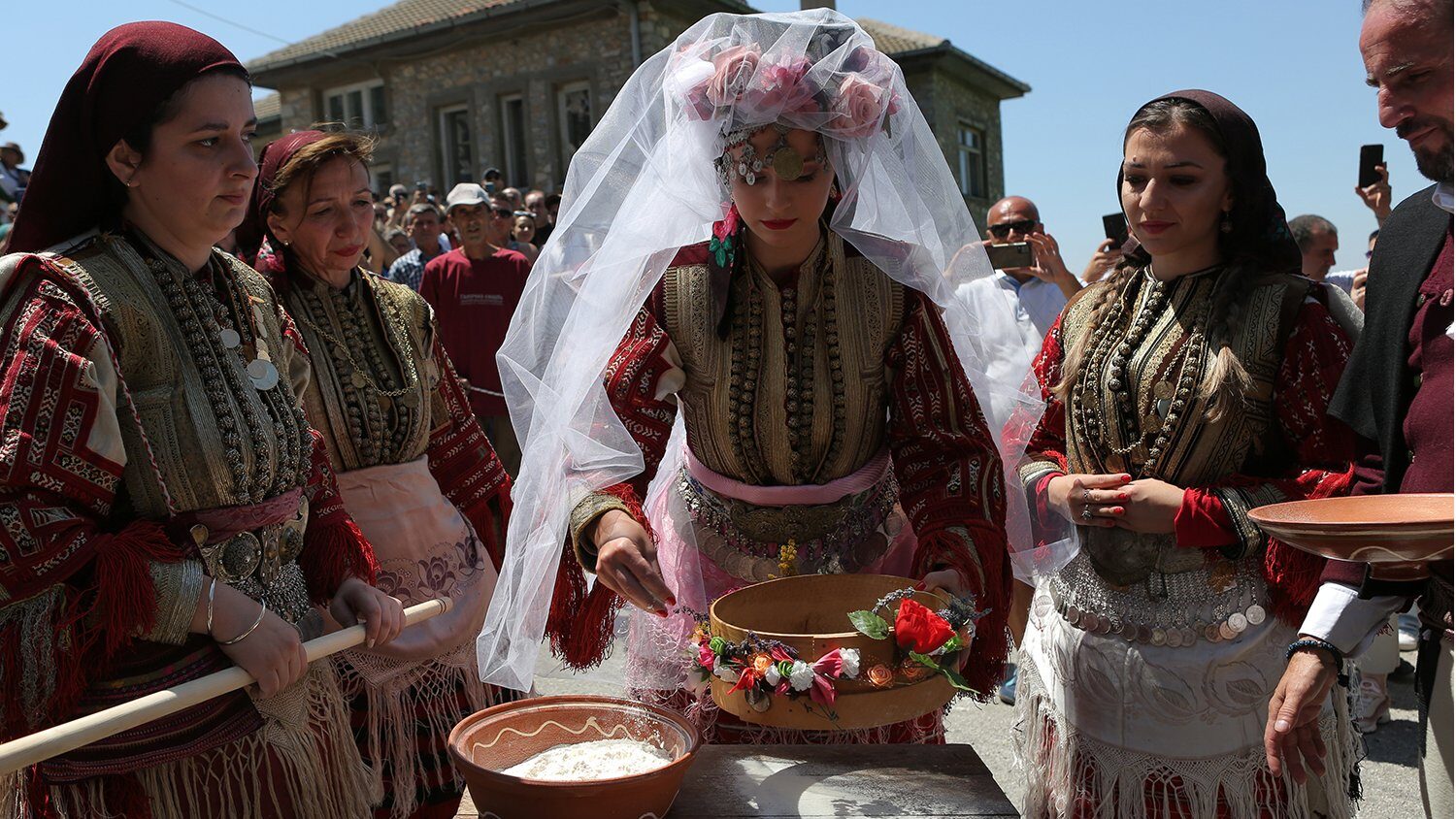 Women in traditional embroidered folk costumes at a community celebration